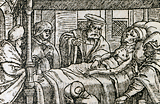 Sick patient in bed surrounded by on-lookers