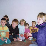 Maria Herran with children in Kosovo, 1998