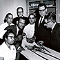 Dr. Berry posing with an international group of students
 and an assortment of medical equipment. Handwriting on back of photo.