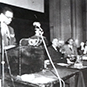 Panoramic view of the convention room with podiums and guests filling the seats.