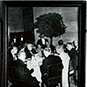 Three small framed photos people in a hall and seated at a table from Dr. Berry's visit at Versailles.