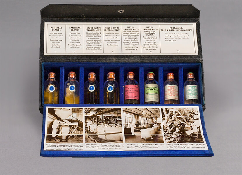 Open sales kit shows eight glass vials representing the steps of manufacturing insulin and includes labels and photographs explaining the steps.