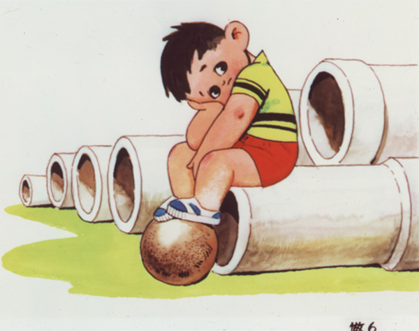 Slide showing a little boy with dark hair, wearing red shorts and a yellow and black shirt, sitting on the end of a long pipe resting on the ground with his head in one hand, his feed on top of a red ball