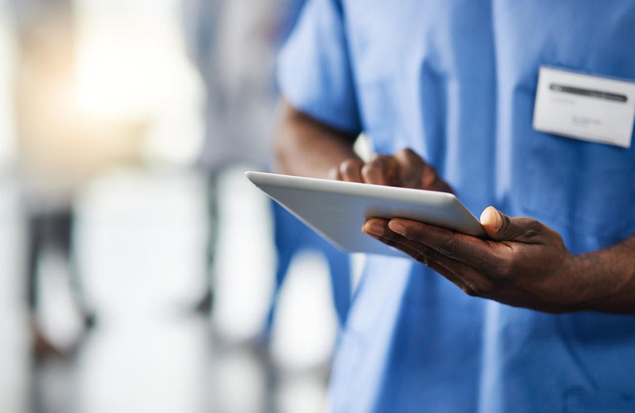 Cropped shot of a doctor using a digital tablet with his colleagues in the background